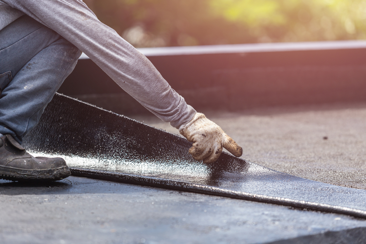 Worker applying sealant on roof