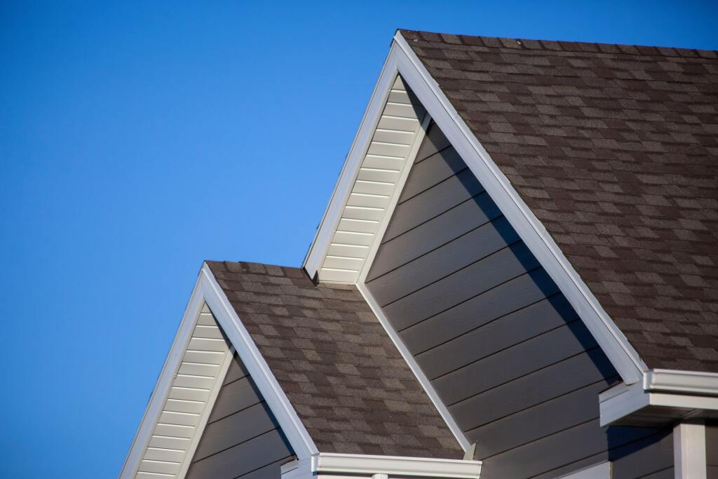 Three gabled roofs against blue sky.