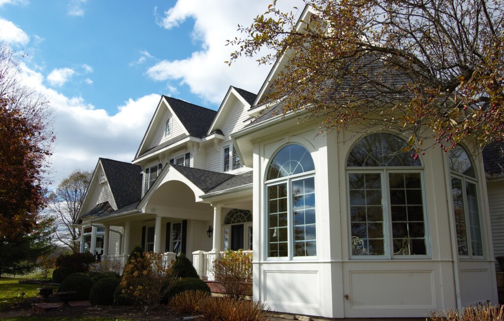 Spacious modern home with large windows and lush garden in daylight.