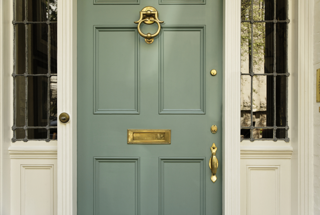 Elegant teal front door with brass knocker and mail slot