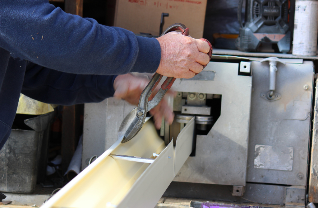 Person using K cutter machine to make custom sized gutters