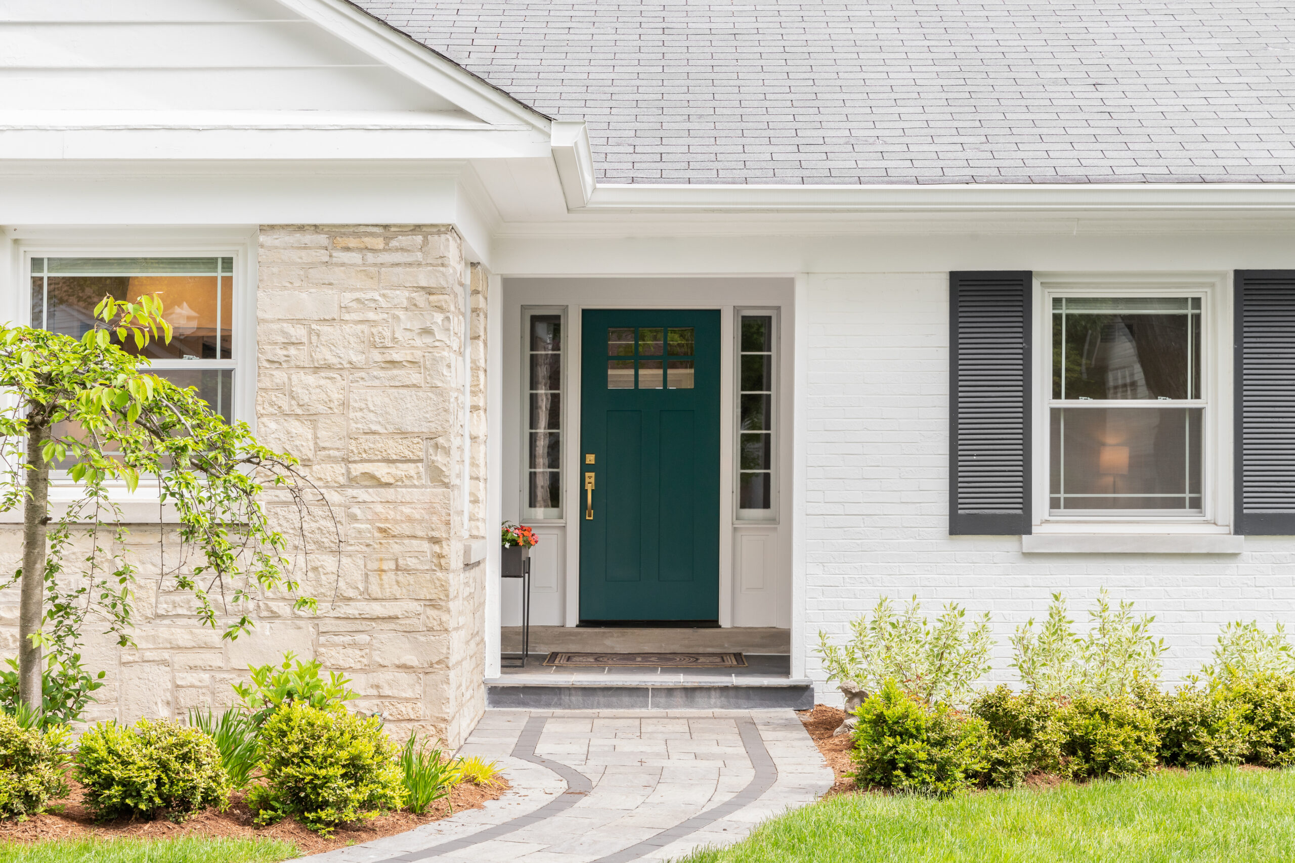 Charming house entrance with blue door and manicured bushes