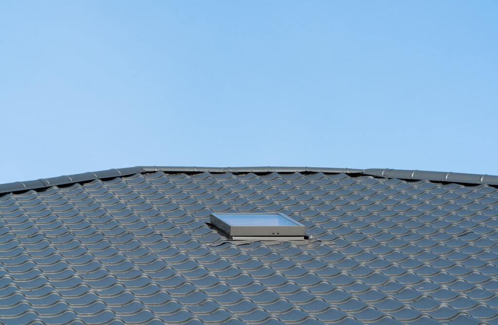 Metal roof with skylight against blue
