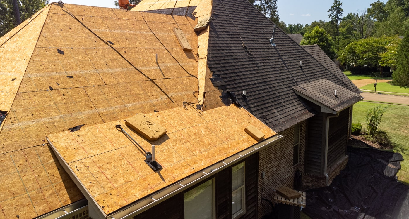 Aerial view of residential roof replacement with new plywood sheathing and shingles