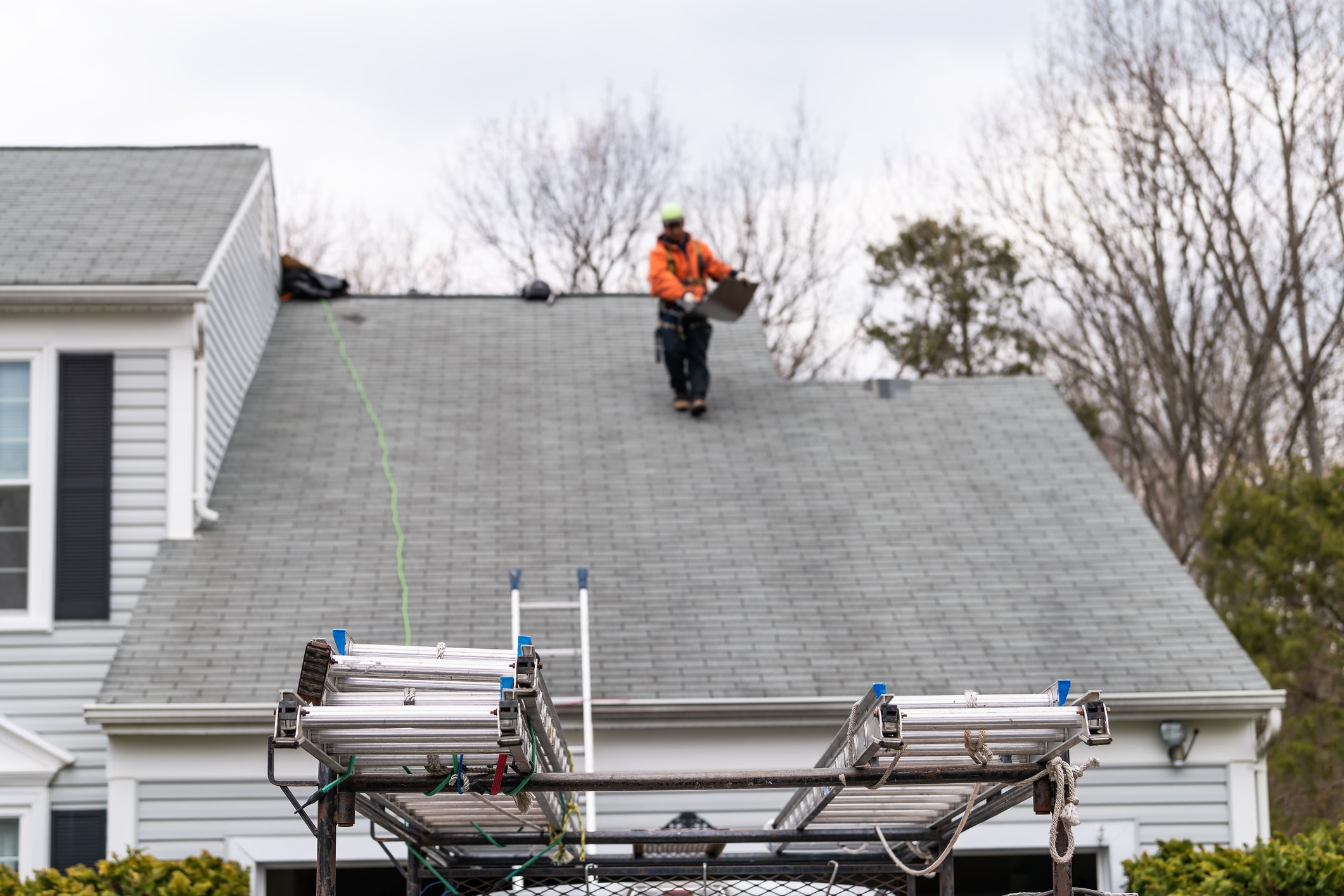 Worker inspecting roof with equipment