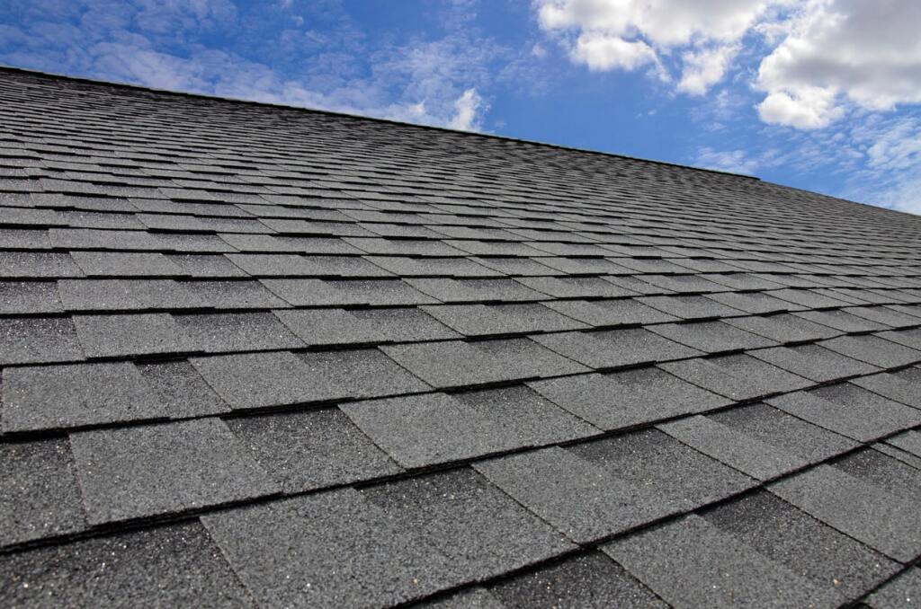 Gray shingle roof under blue sky