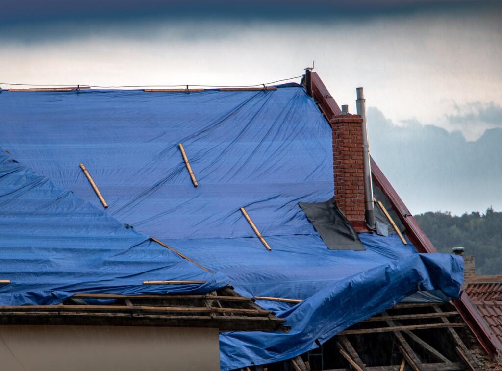 Roof covered with blue tarp